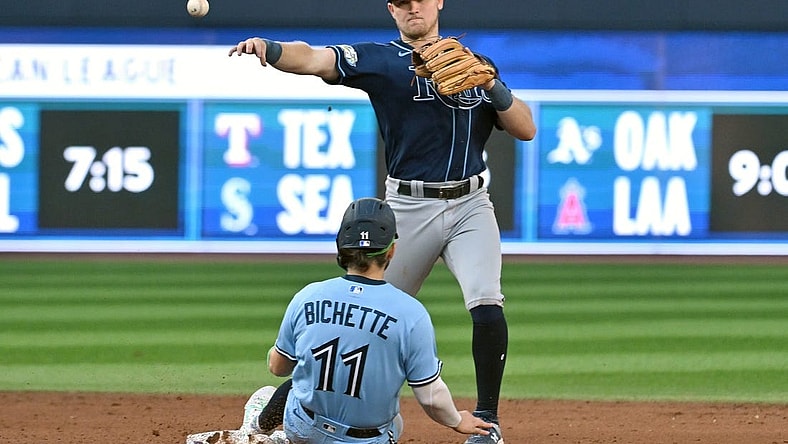 Sep 30, 2023; Toronto, Ontario, CAN;   Tampa Bay Rays second baseman Curtis Mead (25) throws to first for a double play after forcing out Toronto Blue Jays shortstop Bo Bichette (11) in the eighth inning at Rogers Centre. Mandatory Credit: Dan Hamilton-USA TODAY Sports