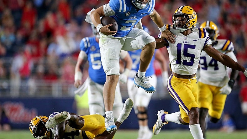 Sep 30, 2023; Oxford, Mississippi, USA; Mississippi Rebels quaterback Jaxson Dart (2) leaps over LSU Tigers defensive back Andre' Sam (14) during the second half at Vaught-Hemingway Stadium. Mandatory Credit: Petre Thomas-USA TODAY Sports