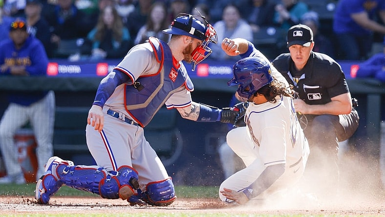 Oct 1, 2023; Seattle, Washington, USA; Seattle Mariners third baseman Eugenio Suarez (28, right) slides home to score a run against Texas Rangers catcher Jonah Heim (28) during the fourth inning at T-Mobile Park. Mandatory Credit: Joe Nicholson-USA TODAY Sports