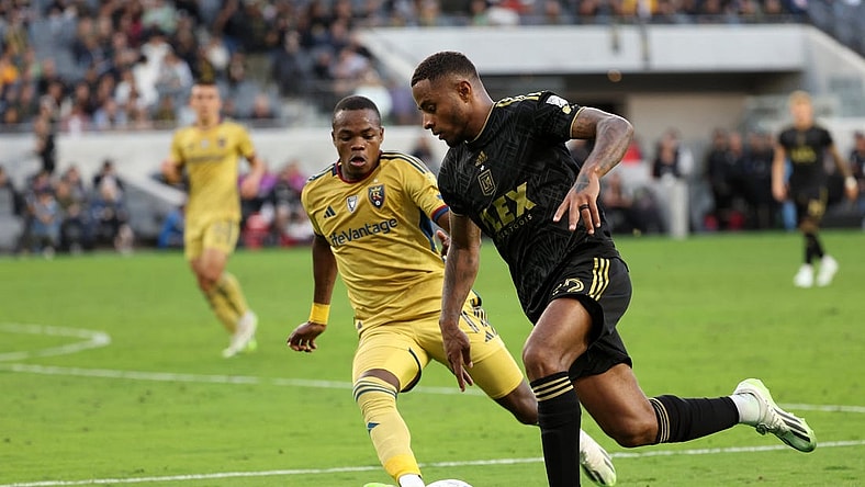 Oct 1, 2023; Los Angeles, California, USA;  Los Angeles FC defender Diego Palacios (12) dribbles the ball against Real Salt Lake forward Carlos Andres Gomez (11) during the first half at BMO Stadium. Mandatory Credit: Kiyoshi Mio-USA TODAY Sports