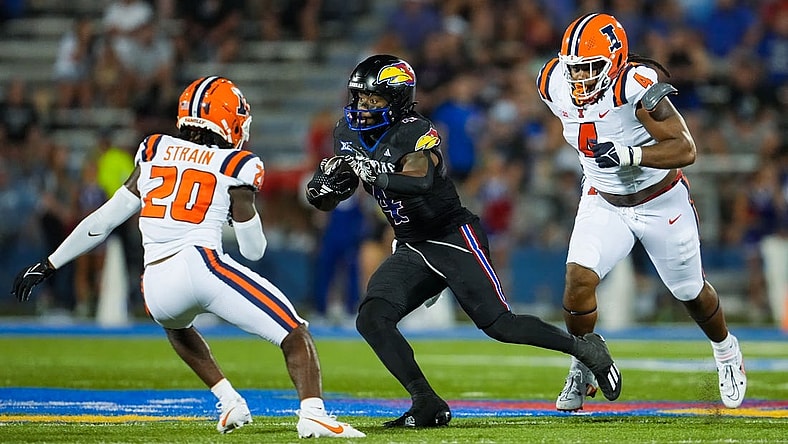 Sep 8, 2023; Lawrence, Kansas, USA; Kansas Jayhawks running back Devin Neal (4) runs the ball against Illinois Fighting Illini defensive back Tyler Strain (20) and defensive lineman Jer'Zhan Newton (4) during the second half at David Booth Kansas Memorial Stadium. Mandatory Credit: Jay Biggerstaff-USA TODAY Sports