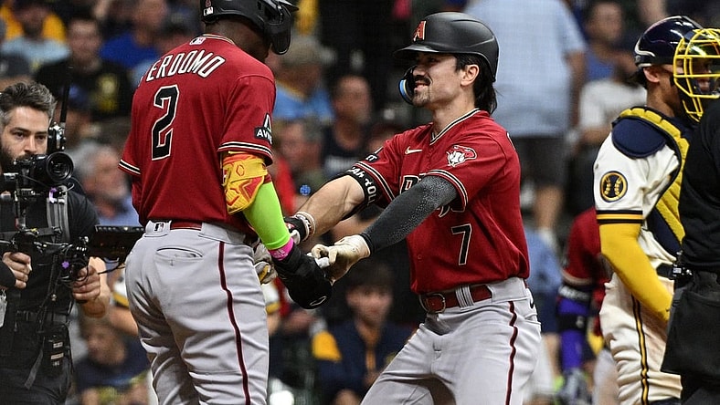 Oct 3, 2023; Milwaukee, Wisconsin, USA; Arizona Diamondbacks shortstop Geraldo Perdomo (2) and left fielder Corbin Carroll (7) celebrate scoring in the third inning against the Milwaukee Brewers during game one of the Wildcard series for the 2023 MLB playoffs at American Family Field. Mandatory Credit: Michael McLoone-USA TODAY Sports