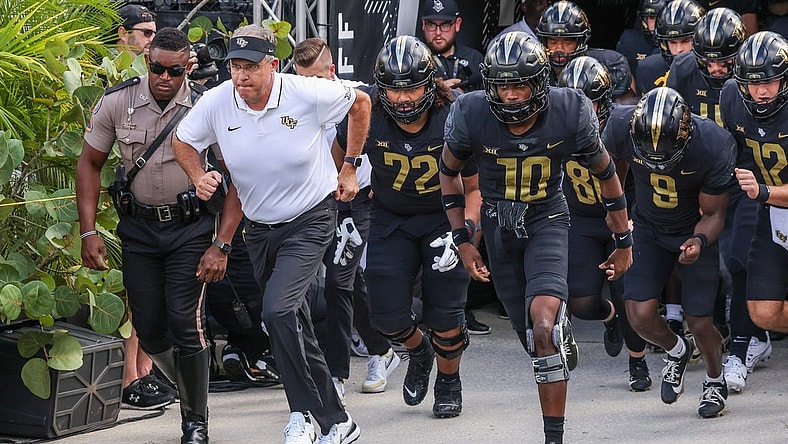 Sep 30, 2023; Orlando, Florida, USA; UCF Knights head coach Gus Malzahn and team run onto the field before the game against the Baylor Bears at FBC Mortgage Stadium. Mandatory Credit: Mike Watters-USA TODAY Sports