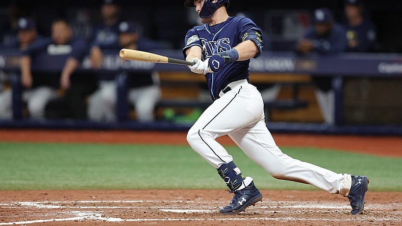 Oct 4, 2023; St. Petersburg, Florida, USA; Tampa Bay Rays second baseman Curtis Mead (25) hits an RBI single against the Texas Rangers in the seventh inning during game two of the Wildcard series for the 2023 MLB playoffs at Tropicana Field. Mandatory Credit: Nathan Ray Seebeck-USA TODAY Sports