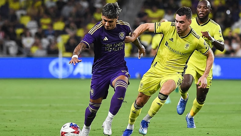 Oct 4, 2023; Nashville, Tennessee, USA; Orlando City forward Facundo Torres (17) dribbles the ball as Nashville SC defender Daniel Lovitz (2) defends during the first half at Geodis Park. Mandatory Credit: Christopher Hanewinckel-USA TODAY Sports