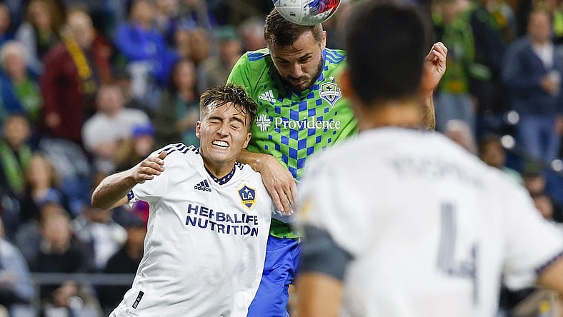 Oct 4, 2023; Seattle, Washington, USA; Seattle Sounders FC forward Jordan Morris (13, right) heads a cross against Los Angeles Galaxy defender Julian Aude (3) during the first half at Lumen Field. Mandatory Credit: Joe Nicholson-USA TODAY Sports