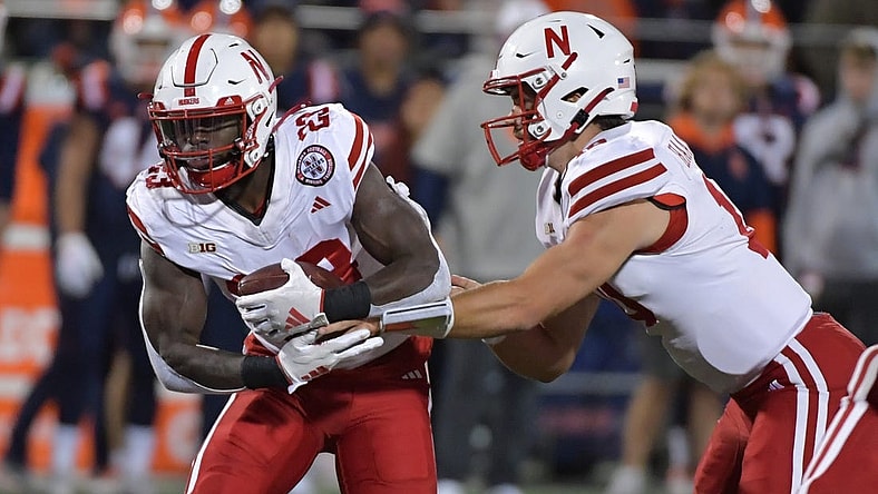 Oct 6, 2023; Champaign, Illinois, USA; Nebraska Cornhuskers quarterback Heinrich Haarberg (10) hands the ball to running back Anthony Grant (23) during the first half against the Illinois Fighting Illini at Memorial Stadium. Mandatory Credit: Ron Johnson-USA TODAY Sports