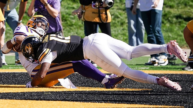 Oct 7, 2023; Columbia, Missouri, USA; LSU Tigers quarterback Jayden Daniels (5) scores a touchdown as Missouri Tigers defensive back Daylan Carnell (13) makes the tackle during the second half at Faurot Field at Memorial Stadium. Mandatory Credit: Denny Medley-USA TODAY Sports