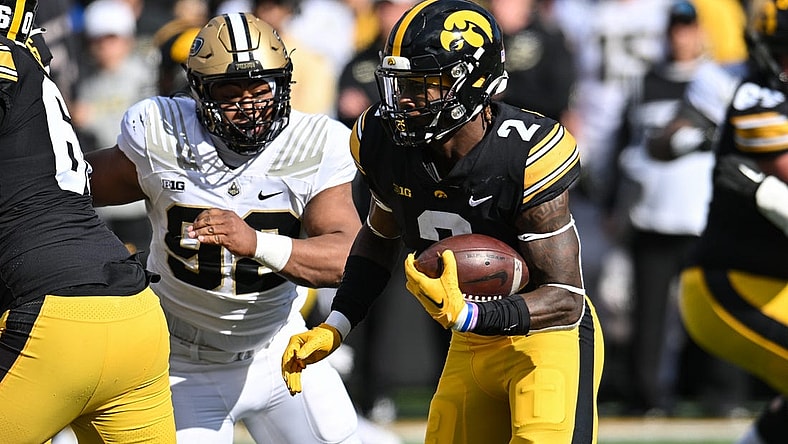 Oct 7, 2023; Iowa City, Iowa, USA; Iowa Hawkeyes running back Kaleb Johnson (2) runs the ball as Purdue Boilermakers defensive lineman Mo Omonode (92) pursues during the first quarter at Kinnick Stadium. Mandatory Credit: Jeffrey Becker-USA TODAY Sports