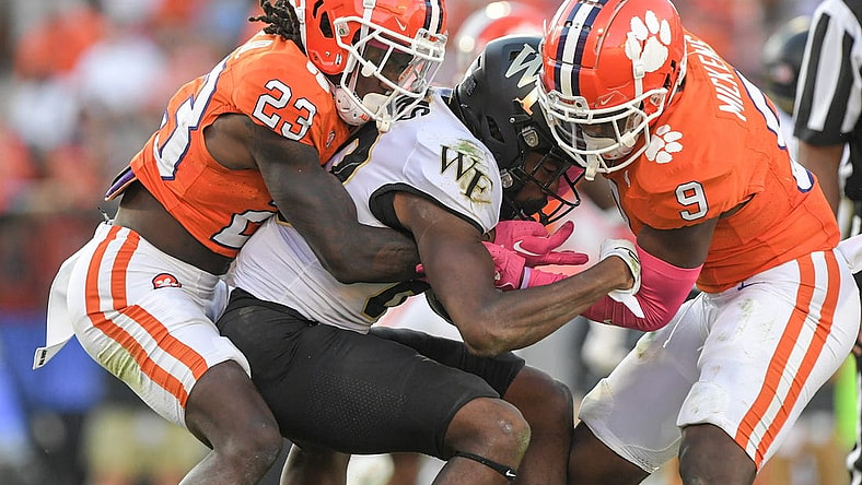 Oct 7, 2023; Clemson, South Carolina, USA; Clemson Tigers cornerback Toriano Pride Jr. (23) and safety R.J. Mickens (9) tackle Wake Forest Demon Deacons defensive back Justin Simpkins (80) during the fourth quarter at Memorial Stadium. Mandatory Credit: Ken Ruinard-USA TODAY Sports