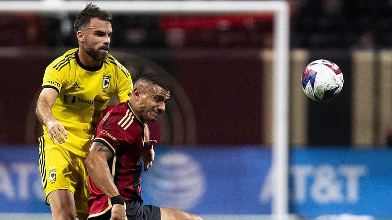 Oct 7, 2023; Atlanta, Georgia, USA; Columbus Crew defender Rudy Camacho (4) holds back Atlanta United forward Giorgos Giakoumakis (7) at Mercedes-Benz Stadium. Mandatory Credit: Julie Bennett-USA TODAY Sports