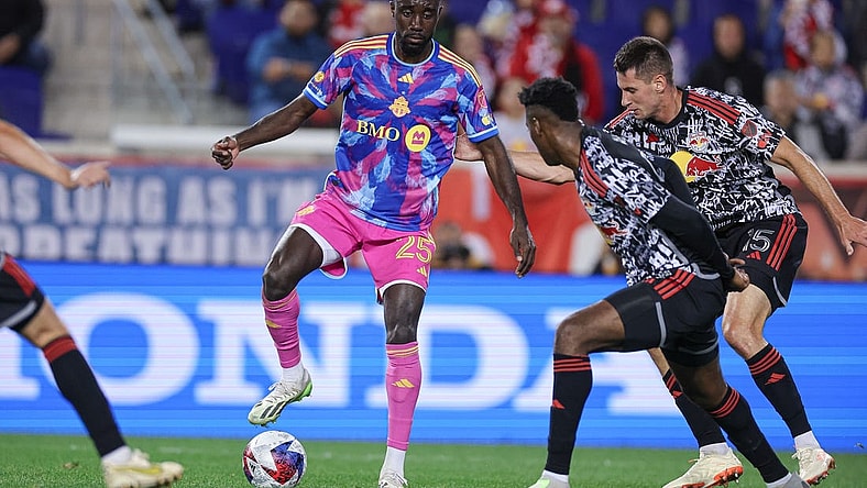 Oct 7, 2023; Harrison, New Jersey, USA; Toronto FC forward Prince Osei Owusu (25) controls the ball as New York Red Bulls defender Hassan Ndam (98) and defender Sean Nealis (15) defend during the first half at Red Bull Arena. Mandatory Credit: Vincent Carchietta-USA TODAY Sports