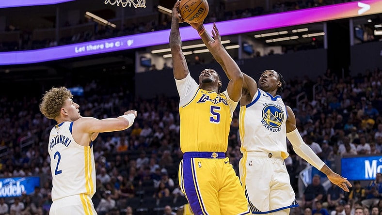 Oct 7, 2023; San Francisco, California, USA; Golden State Warriors guard Brandin Podziemski (2) and forward Jonathan Kuminga (00) defend Los Angeles Lakers forward Cam Reddish (5) during the first half at Chase Center. Mandatory Credit: John Hefti-USA TODAY Sports