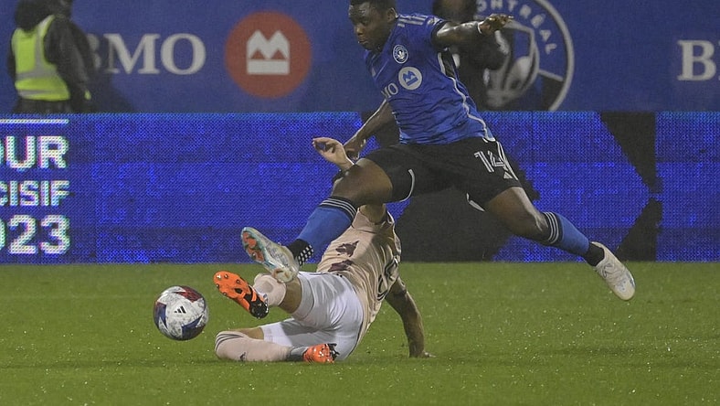 Oct 7, 2023; Montreal, Quebec, CAN; CF Montreal forward Sunusi Ibrahim (14) avoids the tackle of Portland Timbers defender Claudio Bravo (5) in the first half at Stade Saputo. Mandatory Credit: Eric Bolte-USA TODAY Sports