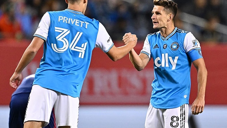 Oct 7, 2023; Chicago, Illinois, USA; Charlotte FC midfielder Andrew Privett (34) and midfielder Ashley Westwood (8) celebrate after a victory over the Chicago Fire FC at Soldier Field. Mandatory Credit: Jamie Sabau-USA TODAY Sports
