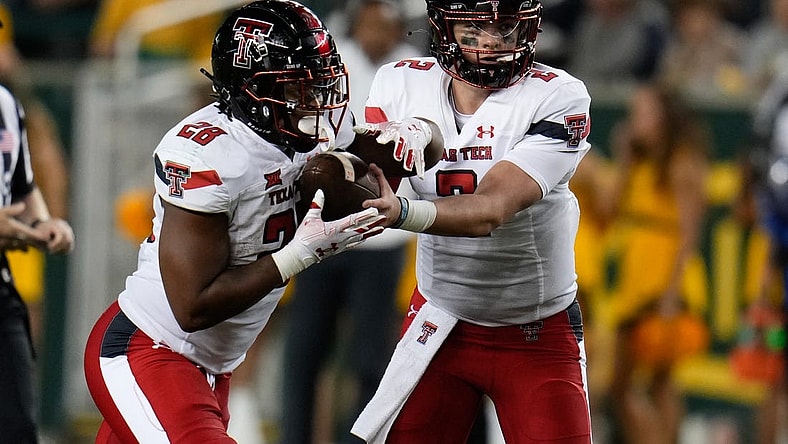 Oct 7, 2023; Waco, Texas, USA; Texas Tech Red Raiders quarterback Behren Morton (2) hands the ball off to Texas Tech Red Raiders running back Tahj Brooks (28) against the Baylor Bears during the second half at McLane Stadium. Mandatory Credit: Chris Jones-USA TODAY Sports