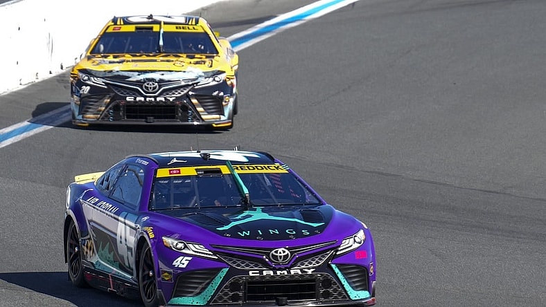 Oct 8, 2023; Concord, North Carolina, USA; NASCAR Cup Series driver Tyler Reddick (45) leads driver Christopher Bell (20) out of turn eight during the Bank of America Roval 400 at Charlotte Motor Speedway Road Course. Mandatory Credit: Jim Dedmon-USA TODAY Sports