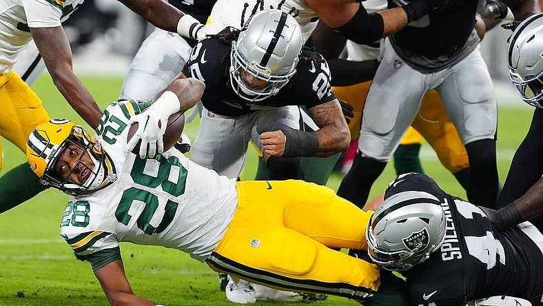 Oct 9, 2023; Paradise, Nevada, USA; Green Bay Packers running back AJ Dillon (28) is tackled by Las Vegas Raiders linebacker Robert Spillane (41) during the first quarter at Allegiant Stadium. Mandatory Credit: Stephen R. Sylvanie-USA TODAY Sports