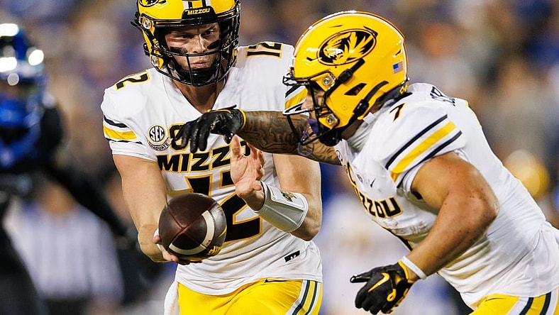 Oct 14, 2023; Lexington, Kentucky, USA; Missouri Tigers quarterback Brady Cook (12) hands the ball to running back Cody Schrader (7) during the first quarter against the Kentucky Wildcats at Kroger Field. Mandatory Credit: Jordan Prather-USA TODAY Sports