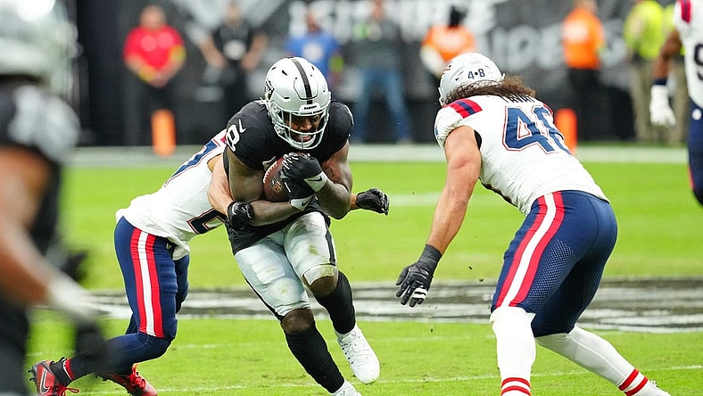 Oct 15, 2023; Paradise, Nevada, USA; Las Vegas Raiders running back Josh Jacobs (8) breaks through a hole against the New England Patriots during the first quarter at Allegiant Stadium. Mandatory Credit: Stephen R. Sylvanie-USA TODAY Sports