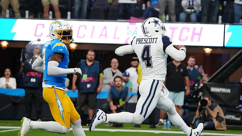 Oct 16, 2023; Inglewood, California, USA; Dallas Cowboys quarterback Dak Prescott (4) scores on an 18-yard touchdown run against Los Angeles Chargers safety Derwin James Jr. (3) in the first half at SoFi Stadium. Mandatory Credit: Kirby Lee-USA TODAY Sports