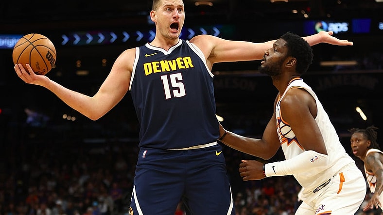 Oct 10, 2023; Phoenix, Arizona, USA; Denver Nuggets center Nikola Jokic (15) against Phoenix Suns forward Chimezie Metu (4) during a preseason game at Footprint Center. Mandatory Credit: Mark J. Rebilas-USA TODAY Sports