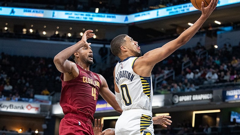 Oct 20, 2023; Indianapolis, Indiana, USA; Indiana Pacers guard Tyrese Haliburton (0) shoots the ball while Cleveland Cavaliers forward Evan Mobley (4) defends in the second half at Gainbridge Fieldhouse. Mandatory Credit: Trevor Ruszkowski-USA TODAY Sports
