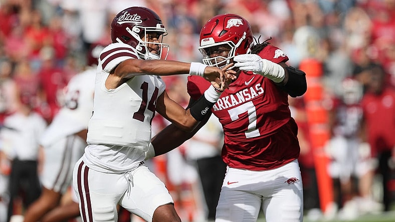 Oct 21, 2023; Fayetteville, Arkansas, USA; Mississippi State Bulldogs quarterback Mike Wright (14) throws a pass against Arkansas Razorbacks defensive lineman Trajan Jeffcoat (7) during the first quarter at Donald W. Reynolds Razorback Stadium. Mandatory Credit: Nelson Chenault-USA TODAY Sports