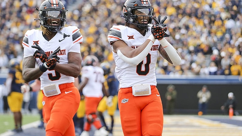 Oct 21, 2023; Morgantown, West Virginia, USA; Oklahoma State Cowboys running back Ollie Gordon II (0) celebrates after running for a touchdown during the first quarter against the West Virginia Mountaineers at Mountaineer Field at Milan Puskar Stadium. Mandatory Credit: Ben Queen-USA TODAY Sports