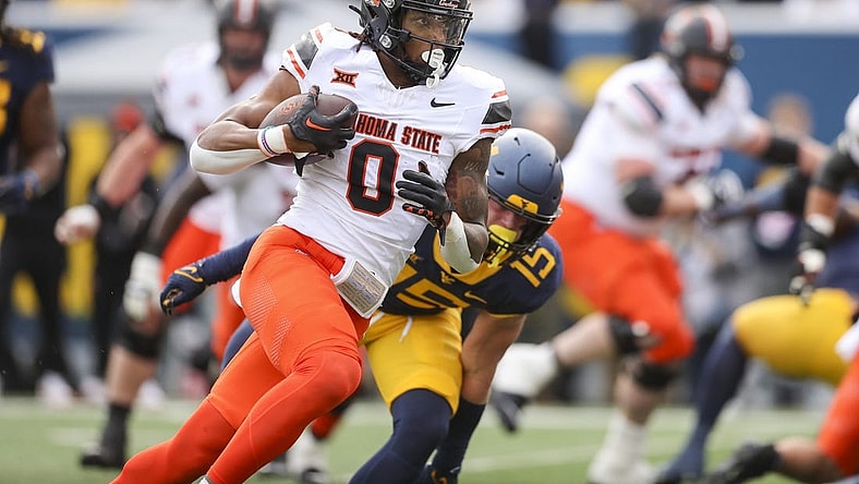 Oct 21, 2023; Morgantown, West Virginia, USA; Oklahoma State Cowboys running back Ollie Gordon II (0) runs for a touchdown during the first quarter against the West Virginia Mountaineers at Mountaineer Field at Milan Puskar Stadium. Mandatory Credit: Ben Queen-USA TODAY Sports
