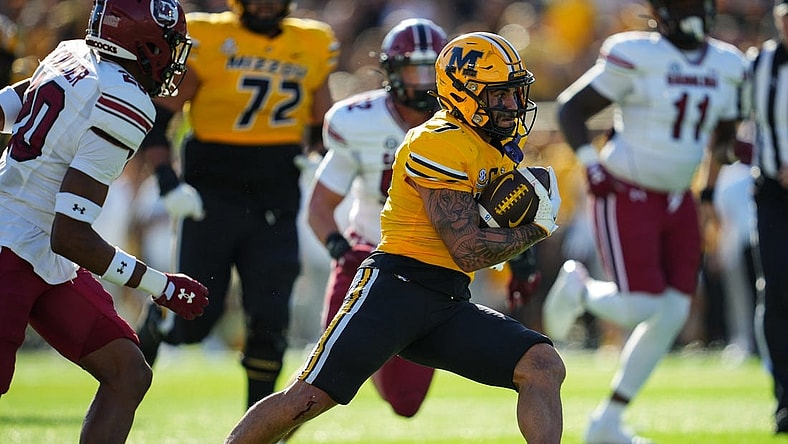 Oct 21, 2023; Columbia, Missouri, USA; Missouri Tigers running back Cody Schrader (7) runs the ball against South Carolina Gamecocks defensive back Judge Collier (20) during the first half at Faurot Field at Memorial Stadium. Mandatory Credit: Jay Biggerstaff-USA TODAY Sports