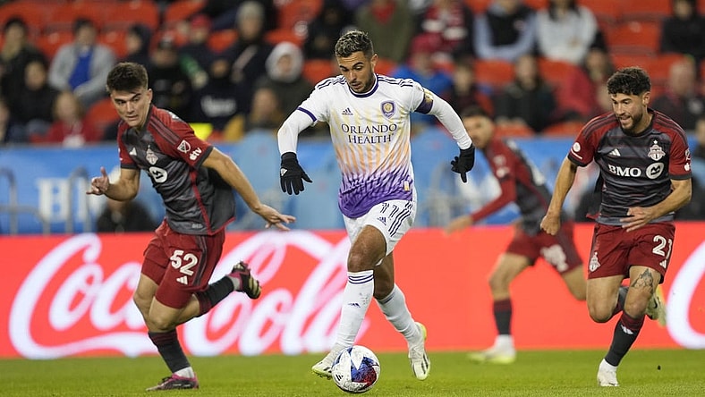 Oct 21, 2023; Toronto, Ontario, CAN; Orlando City SC midfielder Mart n Ojeda (11) dribbles the ball downfield as Toronto FC midfielder Alonso Coello (52)  and midfielder Jonathan Osorio (21)  pursue during the first half at BMO Field. Mandatory Credit: John E. Sokolowski-USA TODAY Sports