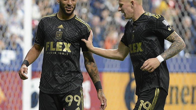 Oct 21, 2023; Vancouver, British Columbia, CAN;  Los Angeles FC midfielder Mateusz Bousz (19) reacts with forward Denis Bouanga (99) during the second half against the Vancouver Whitecaps FC at BC Place. Mandatory Credit: Anne-Marie Sorvin-USA TODAY Sports