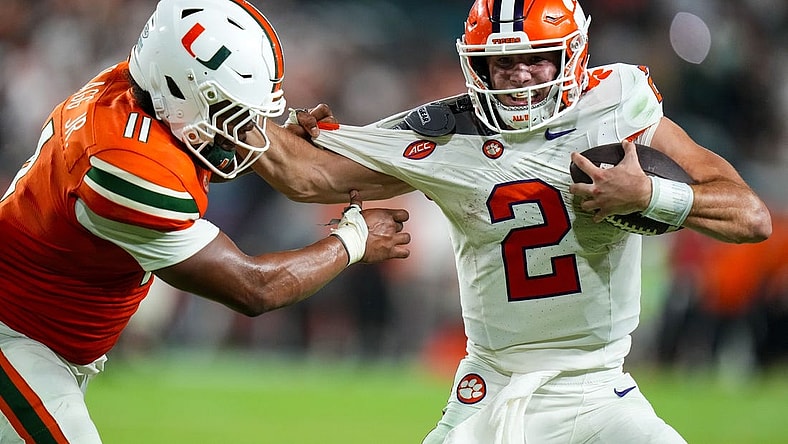 Oct 21, 2023; Miami Gardens, Florida, USA; Miami Hurricanes linebacker Corey Flagg Jr. (11) tackles Clemson Tigers quarterback Cade Klubnik (2) to win the game in over time at Hard Rock Stadium. Mandatory Credit: Rich Storry-USA TODAY Sports