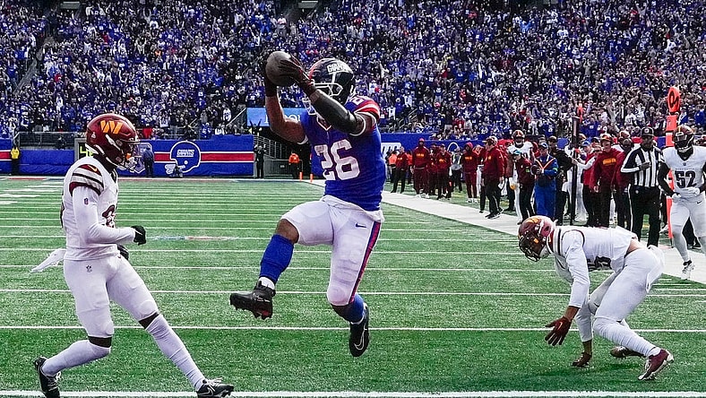 Oct 22, 2023; East Rutherford, New Jersey, USA; New York Giants running back Saquon Barkley (26) scores a  touchdown in the game against the Washington Commanders at MetLife Stadium. Mandatory Credit: Robert Deutsch-USA TODAY Sports