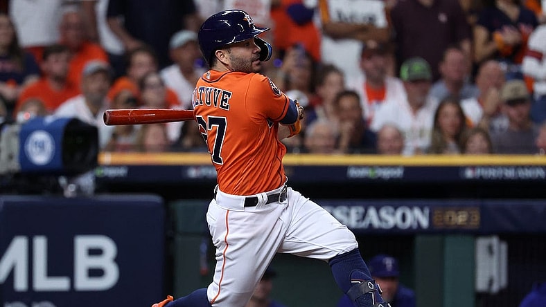Oct 22, 2023; Houston, Texas, USA; Houston Astros second baseman Jose Altuve (27) hits a single against the Texas Rangers in the first inning during game six of the ALCS for the 2023 MLB playoffs at Minute Maid Park. Mandatory Credit: Troy Taormina-USA TODAY Sports