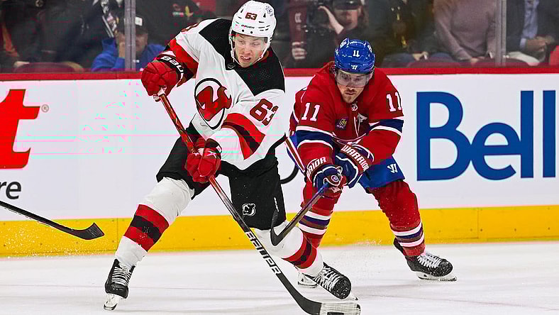 Oct 24, 2023; Montreal, Quebec, CAN; New Jersey Devils left wing Jesper Bratt (63) shoots the puck as Montreal Canadiens right wing Brendan Gallagher (11) defends during the first period at Bell Centre. Mandatory Credit: David Kirouac-USA TODAY Sports