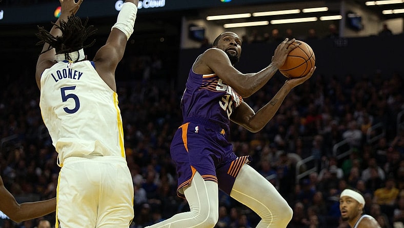 Oct 24, 2023; San Francisco, California, USA; Phoenix Suns forward Kevin Durant (35) shoots around Golden State Warriors forward Kevon Looney (5) during the second quarter at Chase Center. Mandatory Credit: D. Ross Cameron-USA TODAY Sports