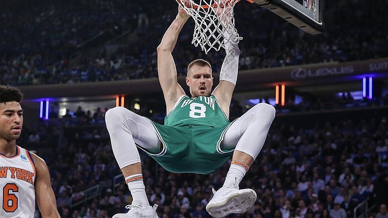 Oct 25, 2023; New York, New York, USA; Boston Celtics center Kristaps Porzingis (8) hangs on the rim after a dunk in the first quarter against the New York Knicks at Madison Square Garden. Mandatory Credit: Wendell Cruz-USA TODAY Sports