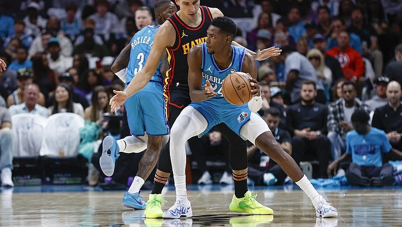 Oct 25, 2023; Charlotte, North Carolina, USA; Charlotte Hornets forward Brandon Miller (24) looks to pass around Atlanta Hawks guard Bogdan Bogdanovic (13) during the first quarter at Spectrum Center. Mandatory Credit: Nell Redmond-USA TODAY Sports