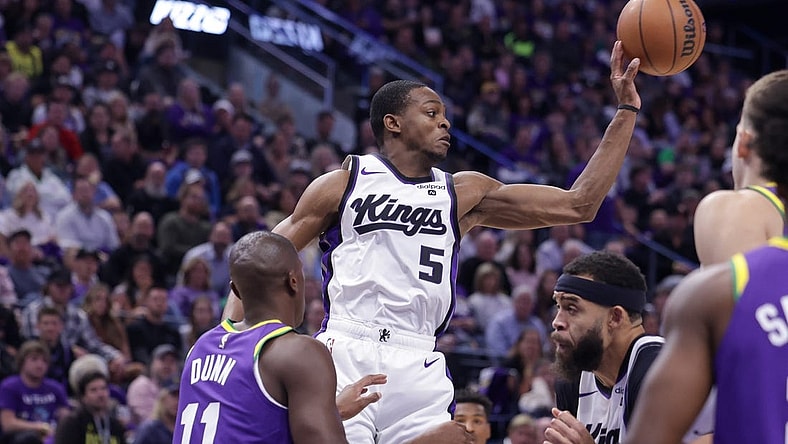 Oct 25, 2023; Salt Lake City, Utah, USA;  Sacramento Kings guard De'Aaron Fox (5) passes the ball away from Utah Jazz guard Kris Dunn (11) during the second quarter at Delta Center. Mandatory Credit: Chris Nicoll-USA TODAY Sports