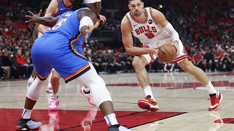Oct 25, 2023; Chicago, Illinois, USA; Chicago Bulls center Nikola Vucevic (9) looks to pass the ball against Oklahoma City Thunder guard Luguentz Dort (5) during the first half of a basketball game at United Center. Mandatory Credit: Kamil Krzaczynski-USA TODAY Sports