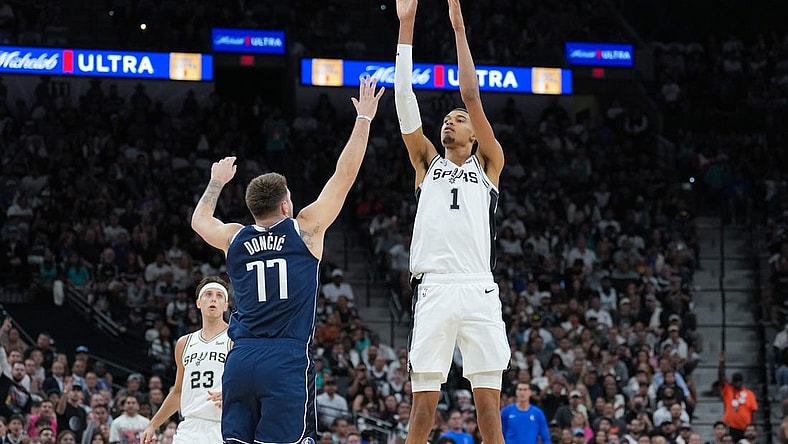 Oct 25, 2023; San Antonio, Texas, USA; San Antonio Spurs center Victor Wembanyama (1) shoots over Dallas Mavericks guard Luka Doncic (77) in the first half at the Frost Bank Center. Mandatory Credit: Daniel Dunn-USA TODAY Sports