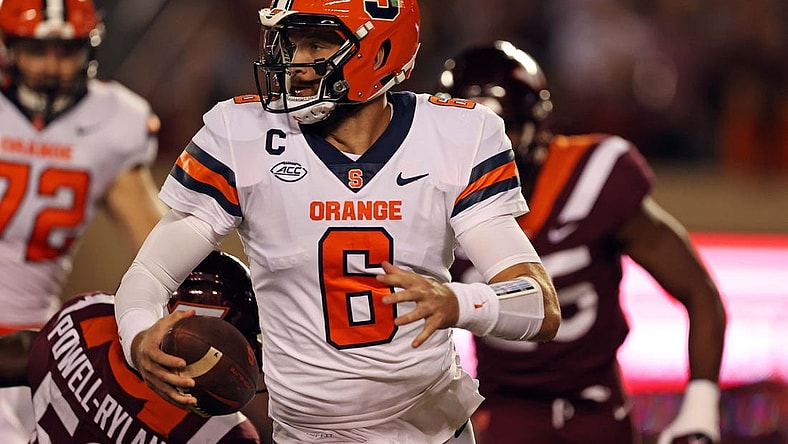 Oct 26, 2023; Blacksburg, Virginia, USA; Syracuse Orange quarterback Garrett Shrader (6) runs away from Virginia Tech Hokies defensive lineman Antwaun Powell-Ryland (52) during the first quarter at Lane Stadium. Mandatory Credit: Peter Casey-USA TODAY Sports