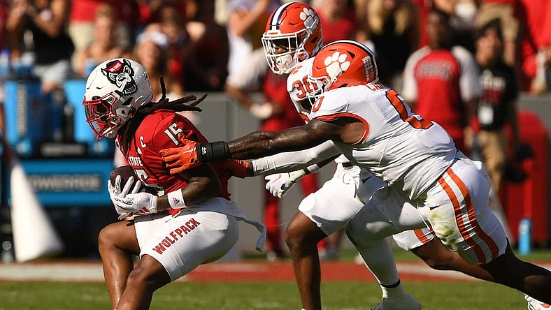 Oct 28, 2023; Raleigh, North Carolina, USA; North Carolina State Wolfpack receiver Keyon Lesane (15) runs after a catch against Clemson Tigers linebacker Barrett Carter (0) and safety Khalil Barnes (36) during the second quarter at Carter-Finley Stadium. Mandatory Credit: Ken Ruinard-USA TODAY Sports