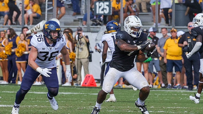 Oct 28, 2023; Orlando, Florida, USA; UCF Knights running back RJ Harvey (7) catches a pass in front of West Virginia Mountaineers linebacker Caden Biser (36) during the second half at FBC Mortgage Stadium. Mandatory Credit: Mike Watters-USA TODAY Sports