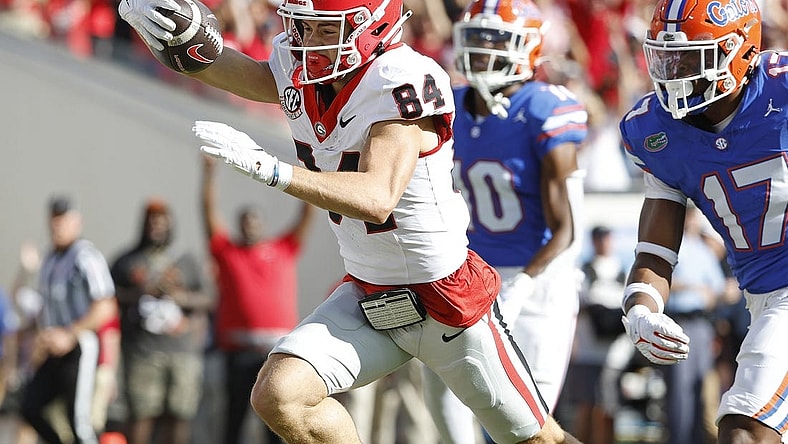 Oct 28, 2023; Jacksonville, Florida, USA; Georgia Bulldogs wide receiver Ladd McConkey (84) stretches for a touchdown past Florida Gators linebacker Scooby Williams (17) in the first half at EverBank Stadium. Mandatory Credit: Jeff Swinger-USA TODAY Sports