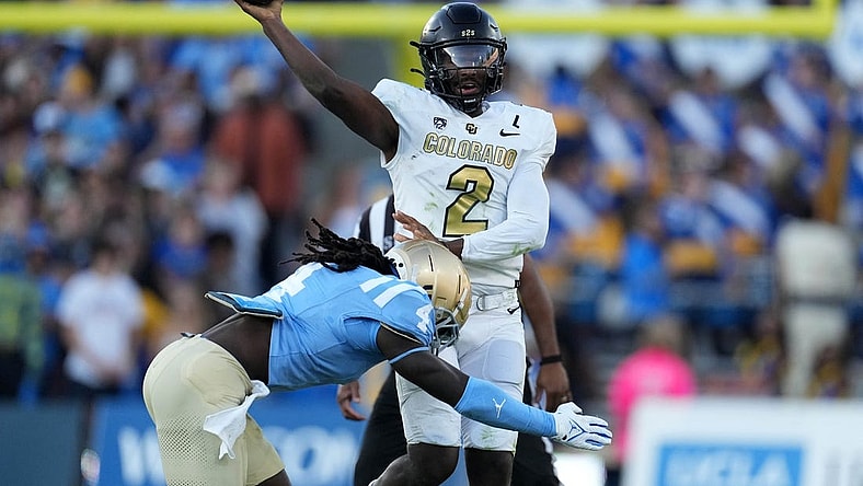 Oct 28, 2023; Pasadena, California, USA; UCLA Bruins quarterback Ethan Garbers (4) throws the ball against UCLA Bruins defensive lineman Carl Jones Jr. (4) in the first half at Rose Bowl. Mandatory Credit: Kirby Lee-USA TODAY Sports