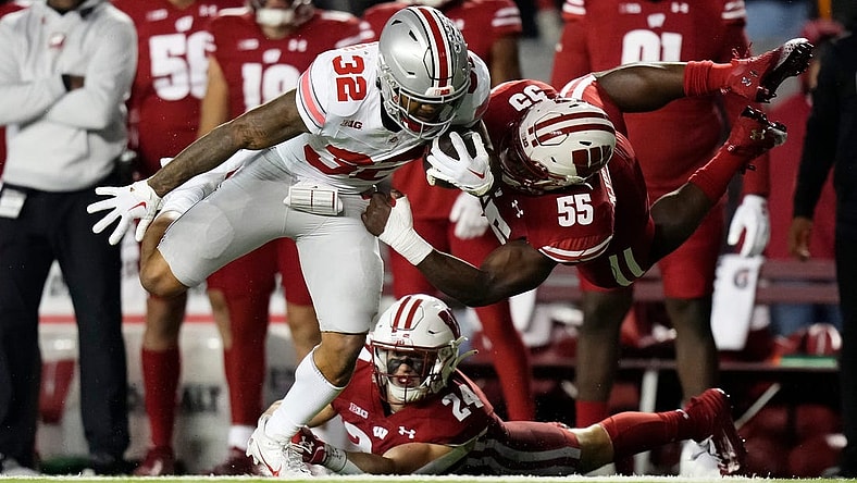 Oct 28, 2023; Madison, Wisconsin, USA; Wisconsin Badgers linebacker Maema Njongmeta (55) attempts to tackle Ohio State Buckeyes running back TreVeyon Henderson (32) during the first half of the NCAA football game at Camp Randall Stadium.