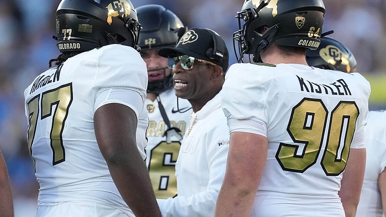 Oct 28, 2023; Pasadena, California, USA; Colorado Buffaloes head coach Deion Sanders talks with offensive tackle Kareem Harden (77) in the first half against the UCLA Bruins at Rose Bowl. Mandatory Credit: Kirby Lee-USA TODAY Sports